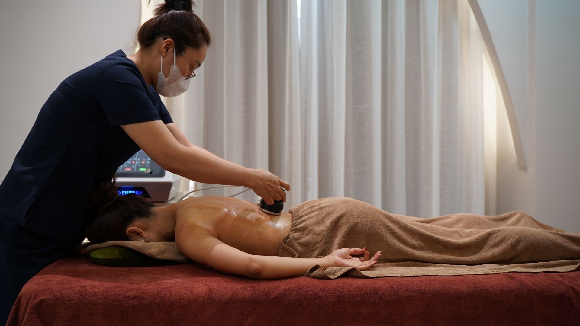 Kỹ thuật viên massage trị liệu cho khách tại KHI
